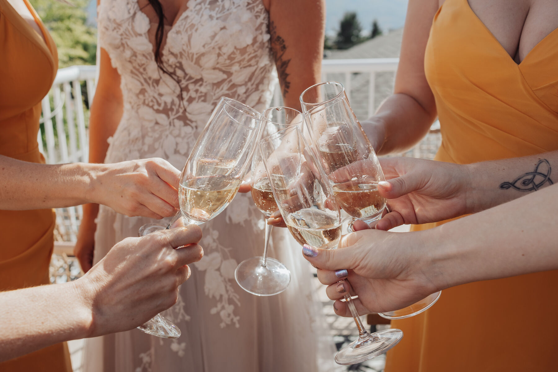 Bride and bridesmaids clinking champagne glasses